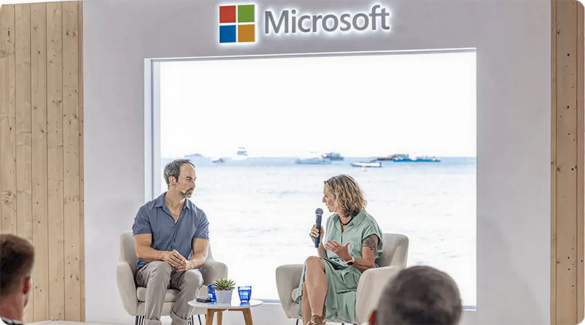 Jonathan Stringfield and Lynne Kjolso, VP of Global Partner and Retail Media at Microsoft, discuss gaming on Microsoft Beach at Cannes Lions 2024.