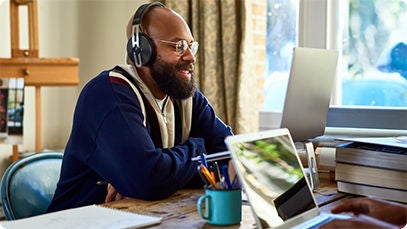 A person using headphones and a laptop indoors.