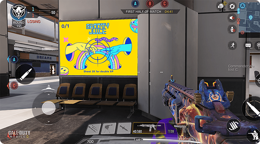 Screenshot from a first-person shooter game showing a player aiming near an in-game billboard displaying a colorful ad.