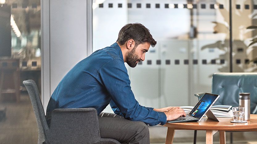 A person sitting at a table using a computer