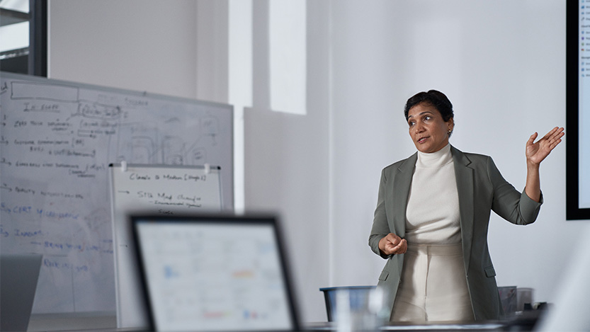 A woman in a room gives a presentation.