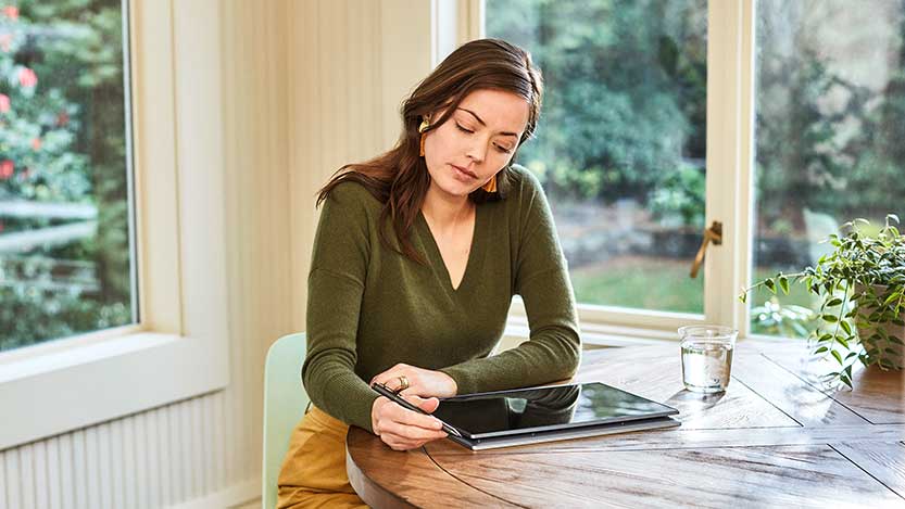 A woman working with her electronic devise in a room.