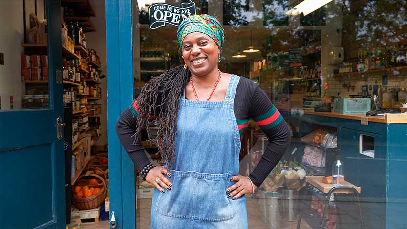 A smiling saleswoman outside the store