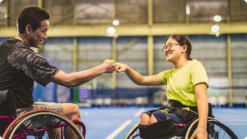 Two people smiling and celebrating in a sports venue.