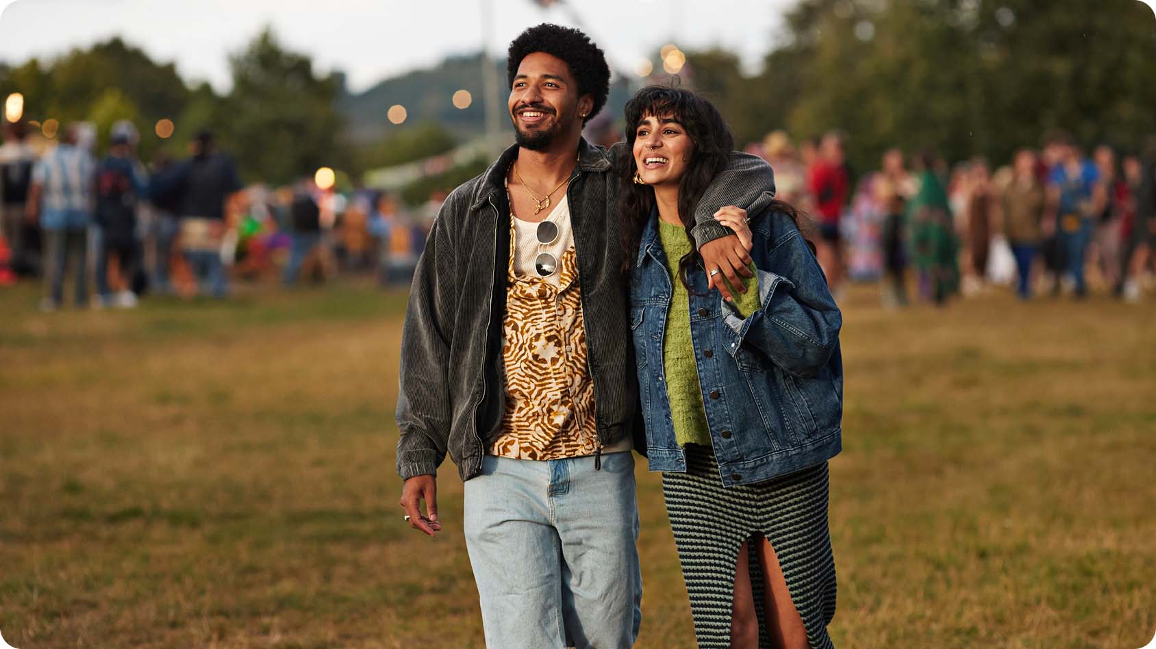 Person wearing a blue sleeveless top holds up a smartphone displaying a Priceline hotel offer for up to 60% off. The background features pink clouds and the Priceline logo with the tagline "Go to your happy price" in blue text.